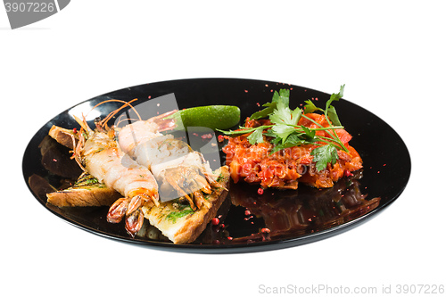 Image of perfect dish with shrimps on a black plate. seafood. Isolated  white background