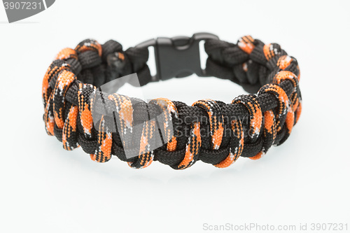 Image of black and orange braided bracelet on white background