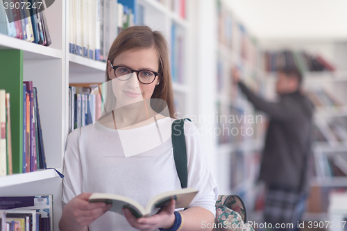 Image of portrait of famale student reading book in library