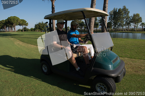 Image of golf players driving cart at course