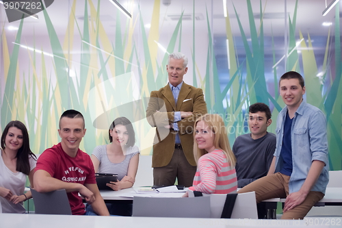 Image of portrait of  teacher with students group in background