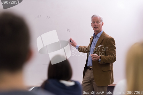 Image of teacher with a group of hi school students in classroom