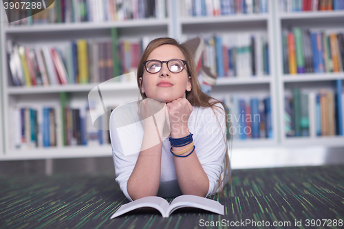 Image of female student study in library, using tablet and searching for 