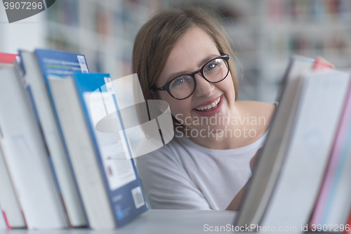 Image of portrait of famale student selecting book to read in library