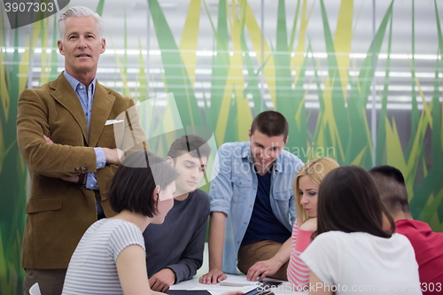 Image of portrait of  teacher with students group in background