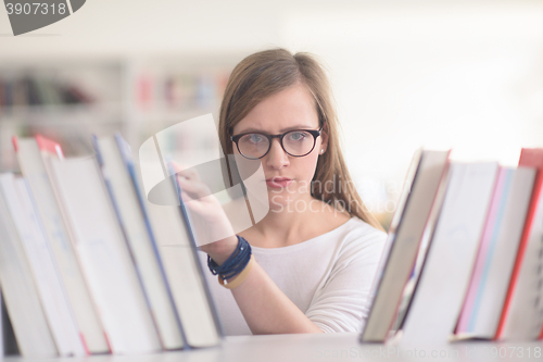 Image of portrait of famale student selecting book to read in library