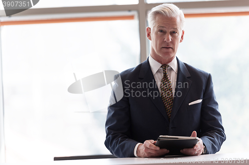 Image of senior business man working on tablet computer