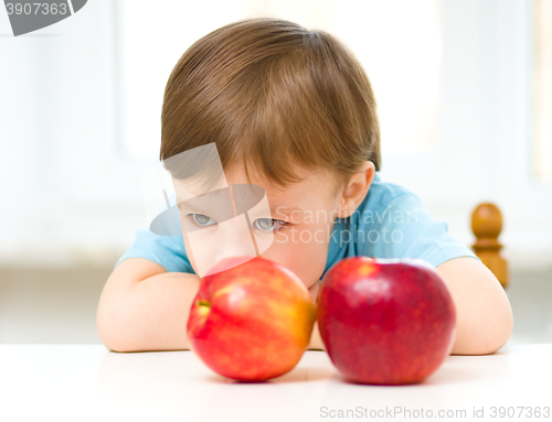 Image of Portrait of a sad little boy with apples