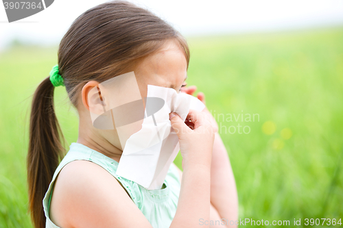 Image of Little girl is blowing her nose