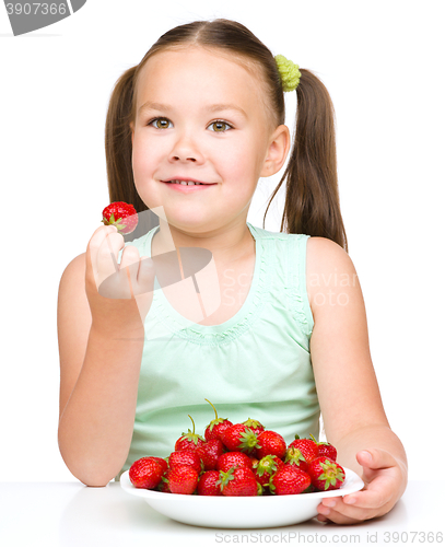 Image of Little girl is eating strawberries