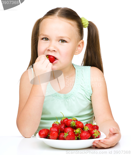 Image of Little girl is eating strawberries