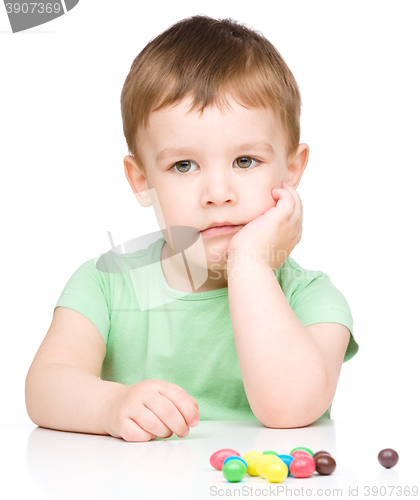 Image of Portrait of a sad little boy with candies