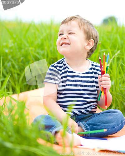 Image of Little boy is playing with pencils