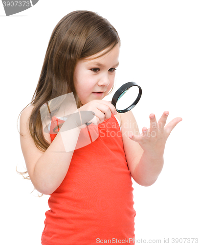 Image of Little girl is looking at her palm using magnifier