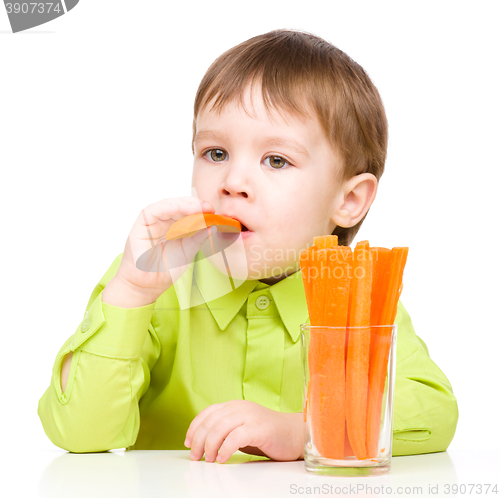 Image of Little boy is eating carrot