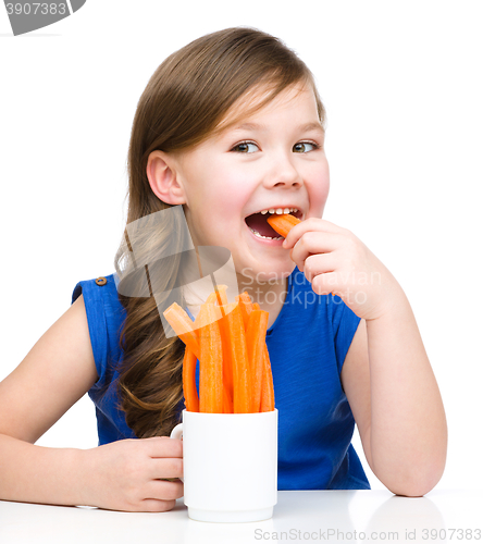 Image of Cute little girl is eating carrot