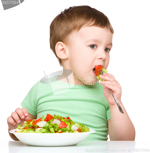 Image of Cute little boy is eating vegetable salad