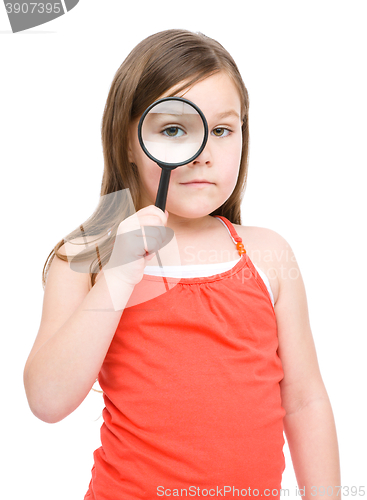 Image of Cute little girl is looking through magnifier