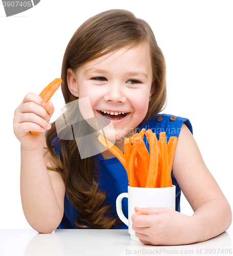 Image of Cute little girl is eating carrot