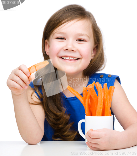 Image of Cute little girl is eating carrot