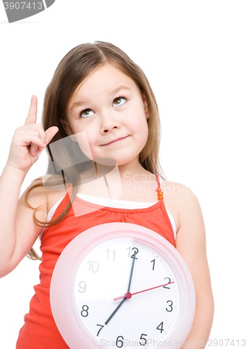 Image of Little girl is holding big clock