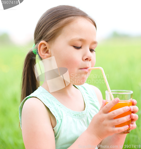 Image of Little girl is drinking orange juice