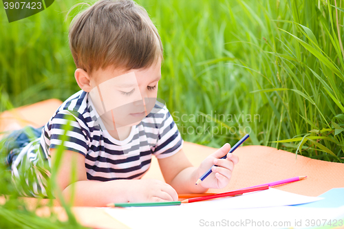 Image of Little boy is playing with pencils