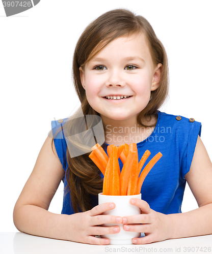 Image of Cute little girl is eating carrot
