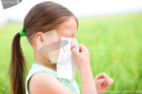 Image of Little girl is blowing her nose