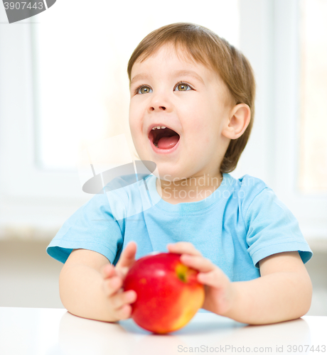 Image of Portrait of a happy little boy with apple