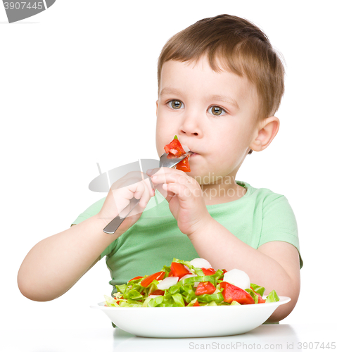 Image of Cute little boy is eating vegetable salad