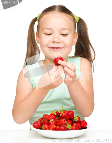 Image of Little girl is eating strawberries