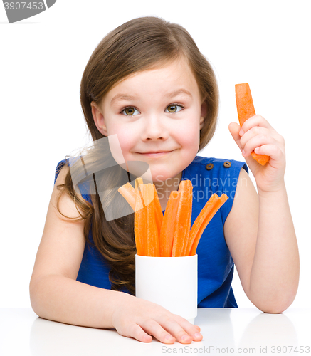Image of Cute little girl is eating carrot