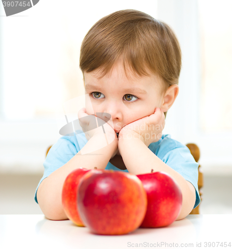 Image of Portrait of a sad little boy with apples