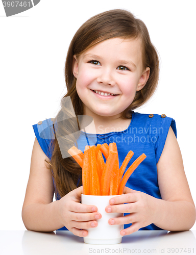 Image of Cute little girl is eating carrot