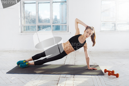 Image of Beautiful slim brunette  doing some push ups a the gym