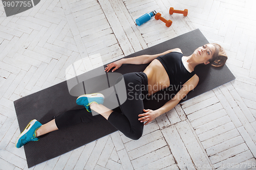 Image of Beautiful slim brunette  doing some stretching exercises in a gym