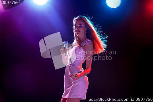 Image of The beautiful girl dancing at the party drinking champagne