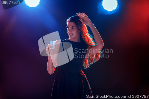Image of The beautiful girl dancing at the party drinking champagne