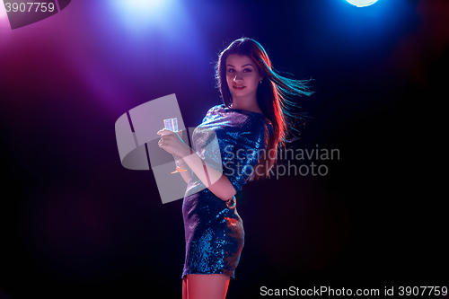 Image of The beautiful girl dancing at the party drinking champagne