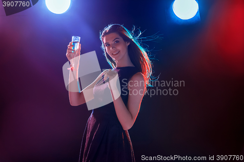 Image of The beautiful girl dancing at the party drinking champagne