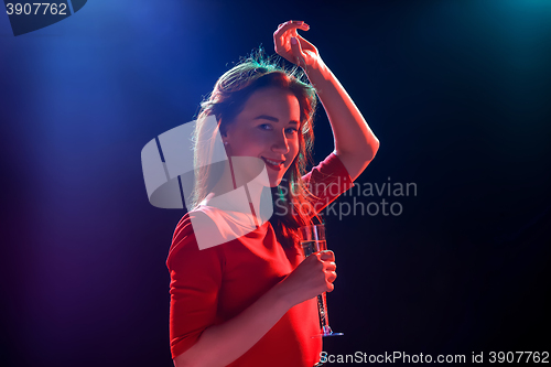 Image of The beautiful girl dancing at the party drinking champagne