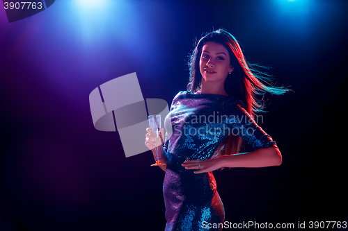 Image of The beautiful girl dancing at the party drinking champagne