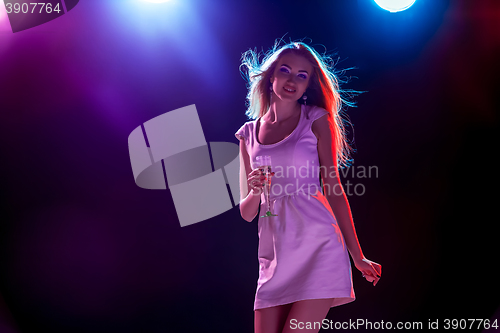 Image of The beautiful girl dancing at the party drinking champagne