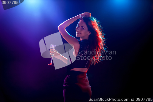 Image of The beautiful girl dancing at the party drinking champagne