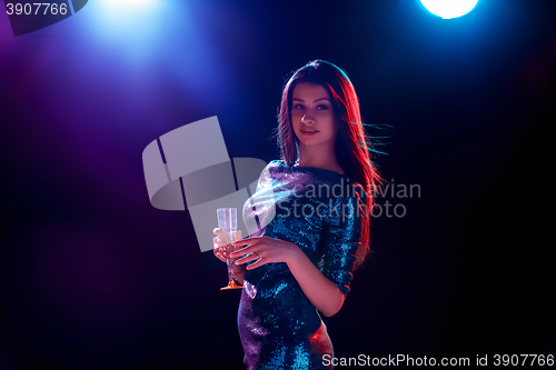 Image of The beautiful girl dancing at the party drinking champagne