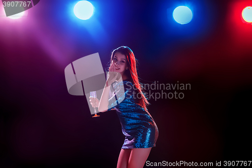 Image of The beautiful girl dancing at the party drinking champagne