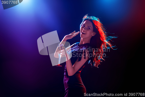 Image of The beautiful girl dancing at the party drinking champagne