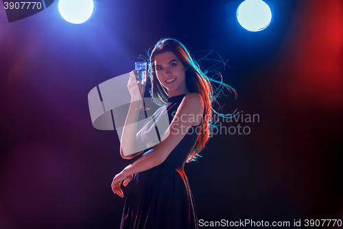 Image of The beautiful girl dancing at the party drinking champagne