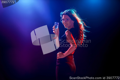 Image of The beautiful girl dancing at the party drinking champagne